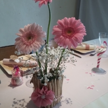 le pot de fleurs a été fait avec des petits bouts de bois flotté avec autour un ruban de perles rose et d'une fleur en tissus fait main.